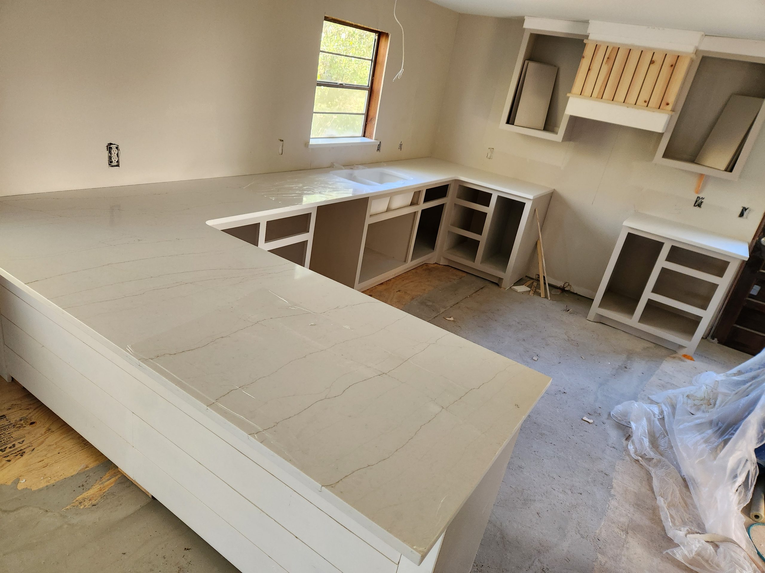 u-shaped kitchen with modern stone countertops and white cabinets