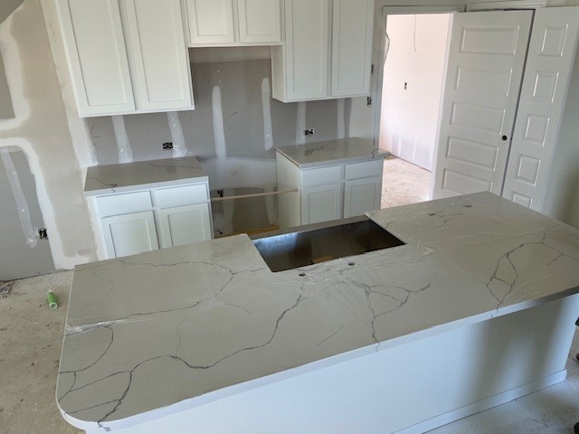 white kitchen with quartz countertops and island