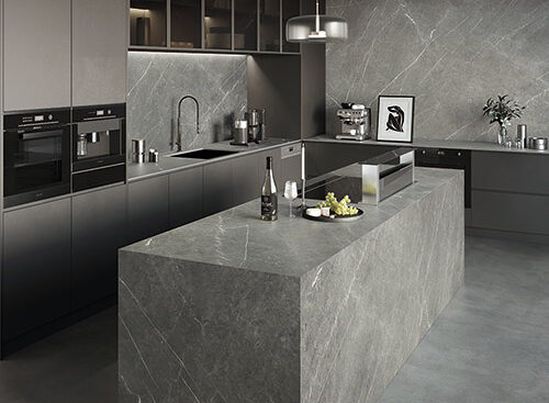 A grey marble backsplash, countertops, and island in a luxurious kitchen. 
